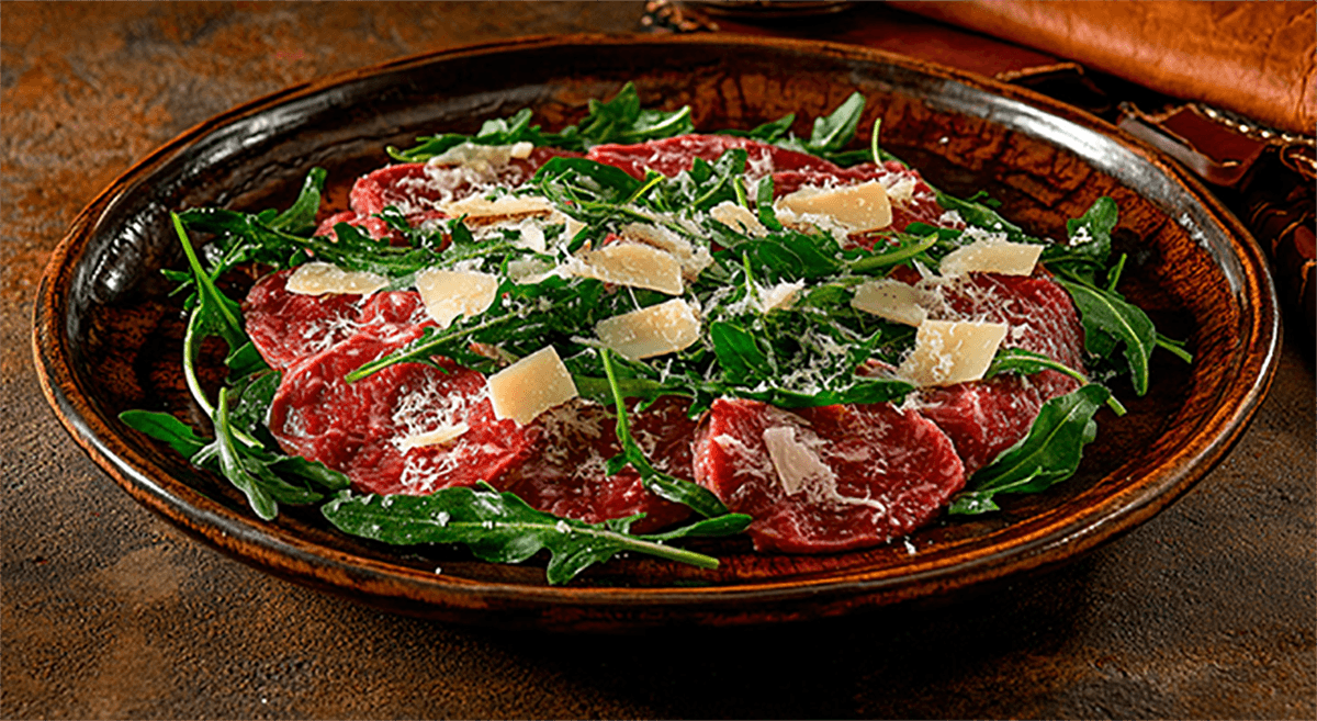 Carpaccio de filé mignon com lascas de parmesão e rúcula selvagem