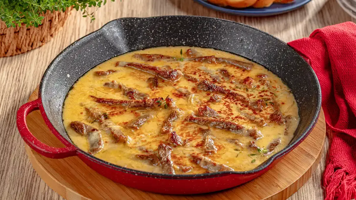 Isca de carne ao molho de cebola com queijo