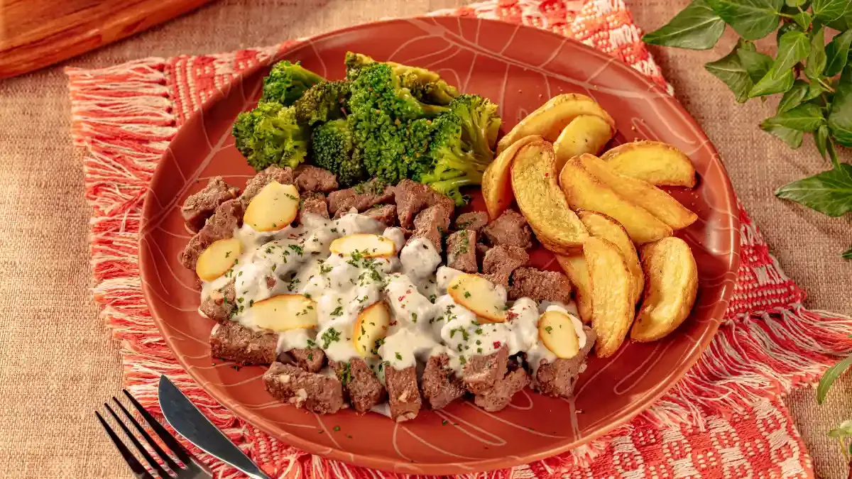 Iscas de carne com molho de parmesão e brócolis